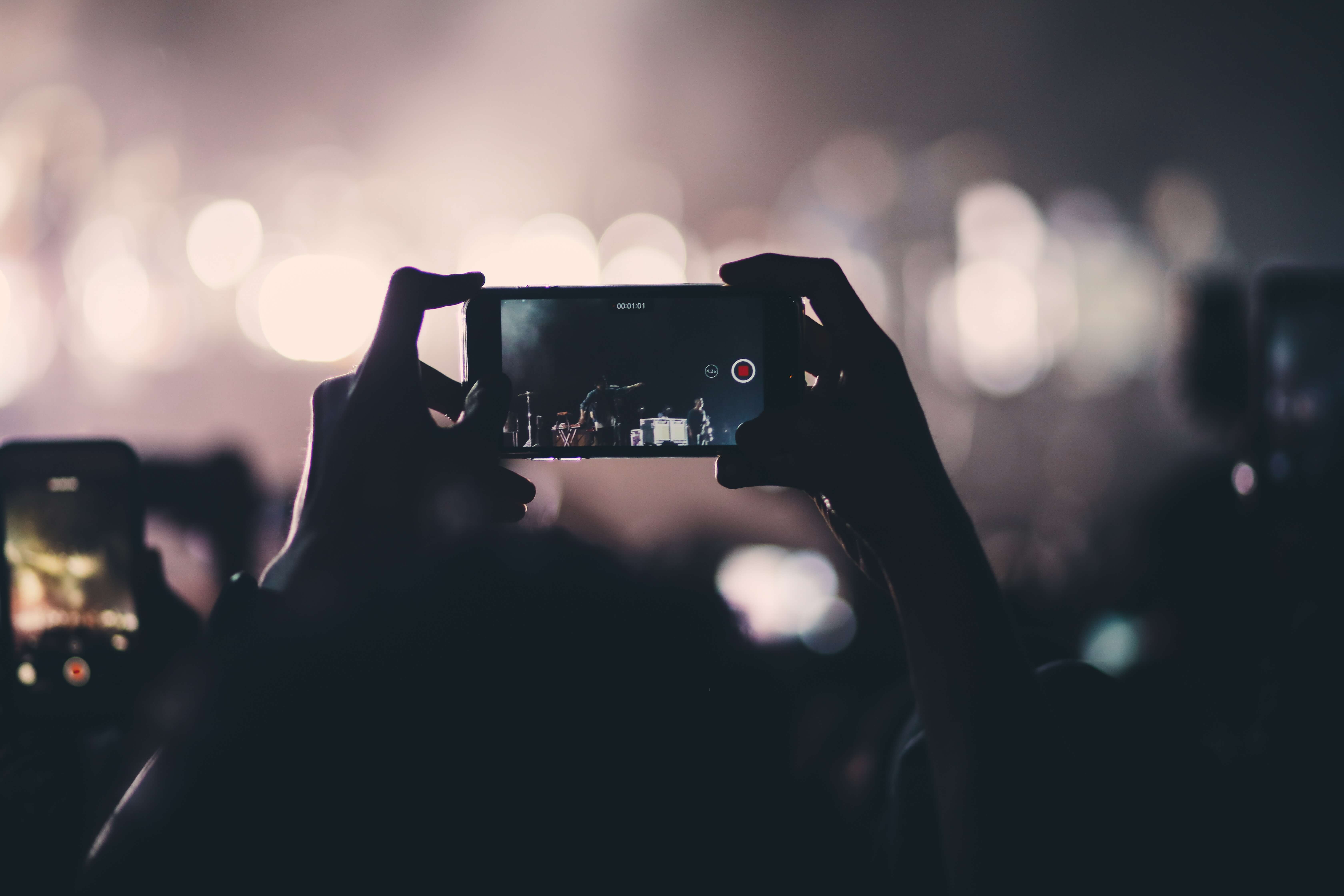 A person holding his phone up horizontally and take a video